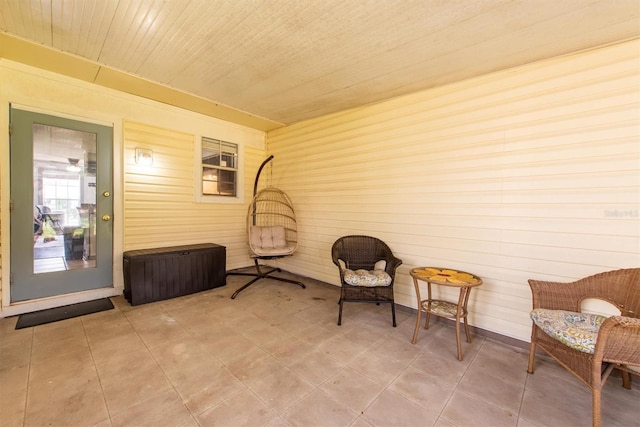 living area with wood walls and wooden ceiling