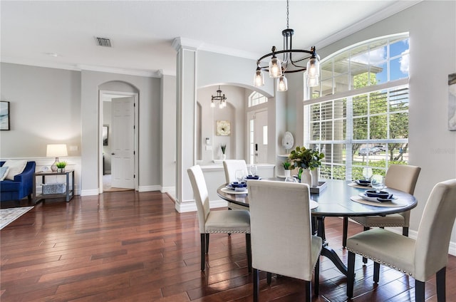 dining area featuring a chandelier, arched walkways, ornamental molding, dark wood-style flooring, and baseboards