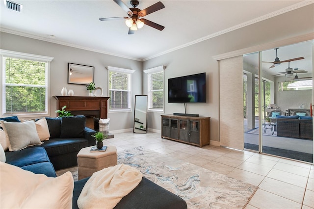 living area with ceiling fan, tile patterned floors, crown molding, baseboards, and a fireplace