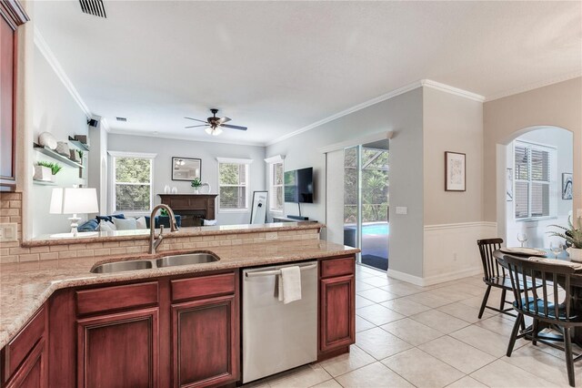 kitchen featuring dishwasher, a sink, ceiling fan, open floor plan, and arched walkways