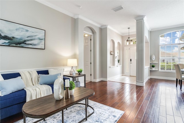 living area with arched walkways, wood finished floors, ornamental molding, and baseboards