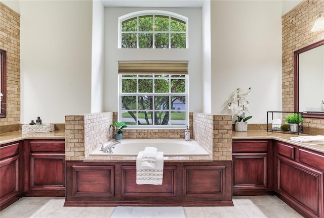 full bathroom featuring a high ceiling, a bath, tile patterned flooring, and vanity