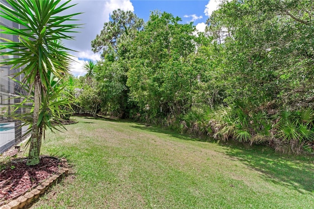 view of green lawn featuring central AC