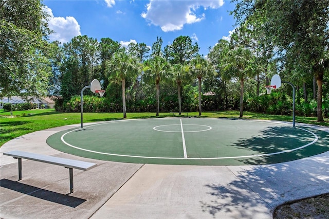 view of sport court with a yard, community basketball court, and view of wooded area