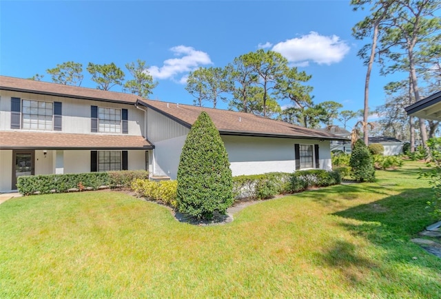 view of side of home featuring a lawn and stucco siding