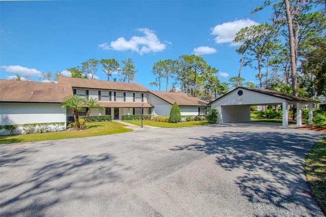 view of front of home with driveway, a balcony, and a carport