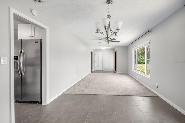 interior space with a chandelier, a textured ceiling, and baseboards