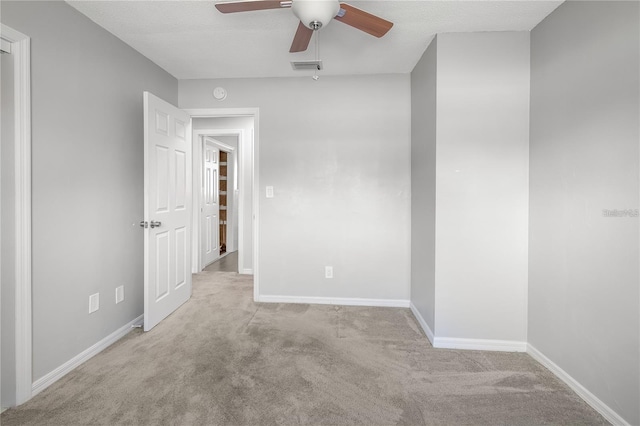 unfurnished room featuring a ceiling fan, visible vents, light carpet, and baseboards