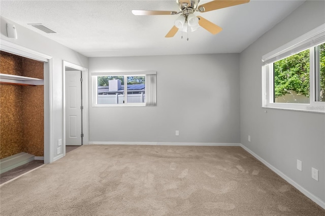 unfurnished bedroom featuring visible vents, baseboards, ceiling fan, a textured ceiling, and carpet floors