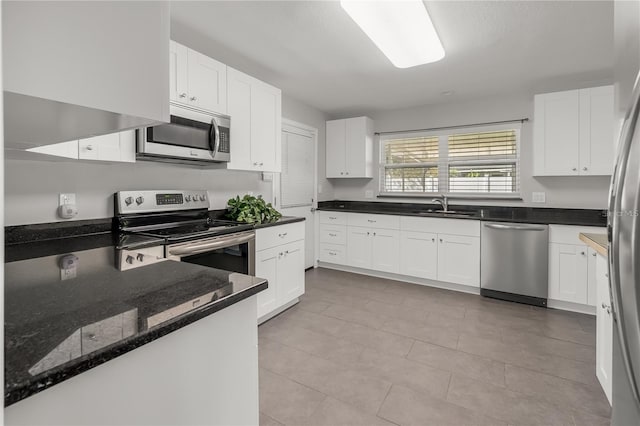 kitchen with appliances with stainless steel finishes, a sink, and white cabinetry