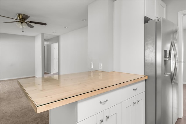 kitchen with carpet floors, light countertops, white cabinetry, a peninsula, and stainless steel fridge with ice dispenser