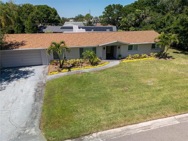 ranch-style home featuring a garage, concrete driveway, a front lawn, and stucco siding