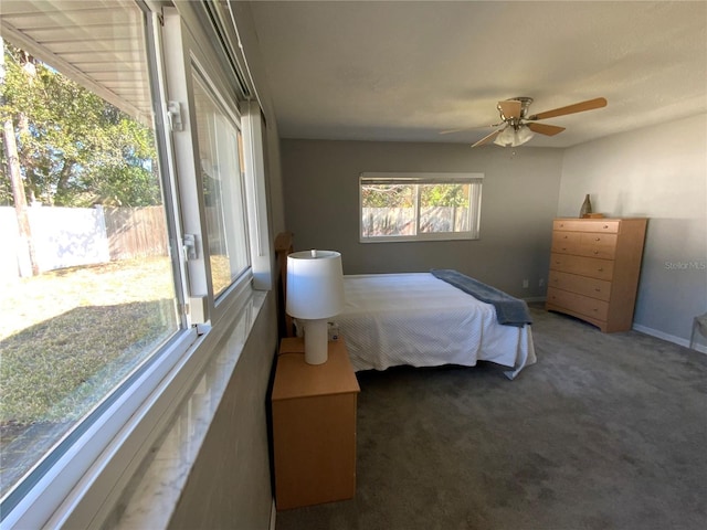 bedroom featuring dark carpet, a ceiling fan, and baseboards