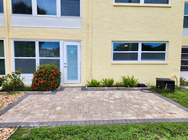 property entrance featuring cooling unit and a patio area