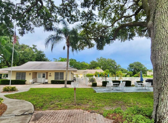 back of house featuring a patio area and a lawn