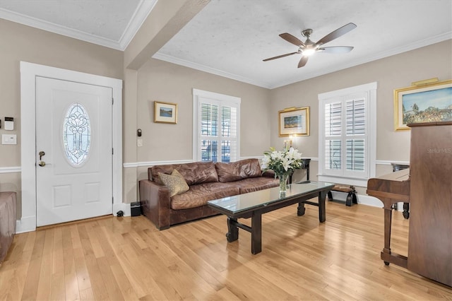 entryway featuring light wood-type flooring, ceiling fan, and crown molding