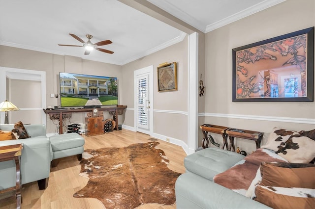 living area with a ceiling fan, crown molding, light wood-style flooring, and baseboards