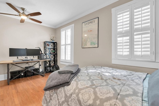 bedroom featuring ornamental molding, wood finished floors, a ceiling fan, and baseboards