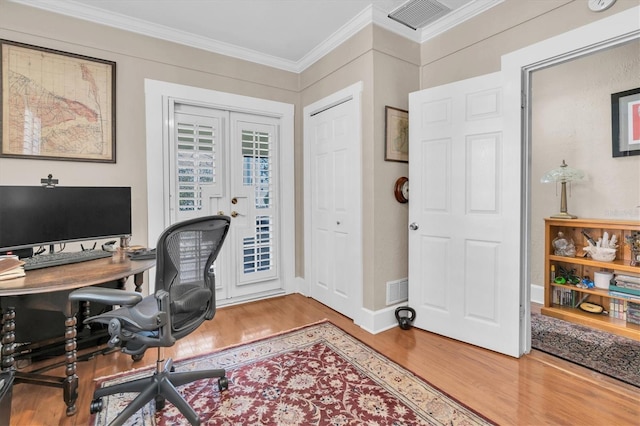 office space with french doors, visible vents, crown molding, and wood finished floors