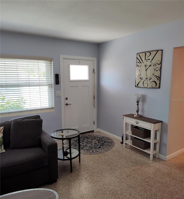 entryway featuring baseboards and speckled floor