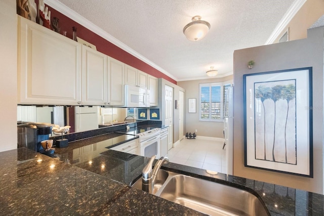 kitchen featuring a textured ceiling, white appliances, white cabinetry, ornamental molding, and dark countertops