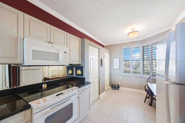 kitchen featuring a textured ceiling, light tile patterned floors, white appliances, baseboards, and ornamental molding