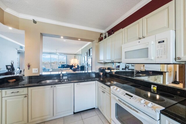 kitchen with a textured ceiling, white appliances, a sink, and crown molding