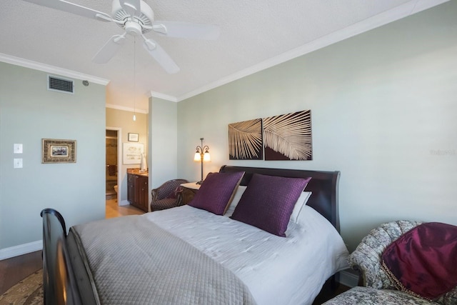 bedroom featuring crown molding, visible vents, ensuite bath, wood finished floors, and baseboards