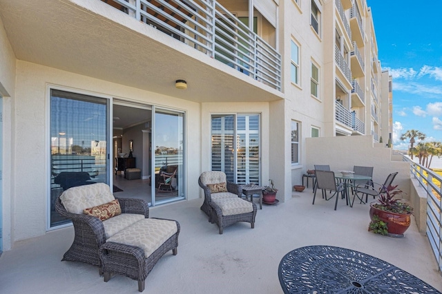 view of patio with outdoor dining space and a balcony