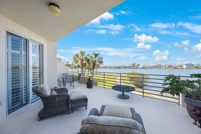 view of patio with a water view and a balcony