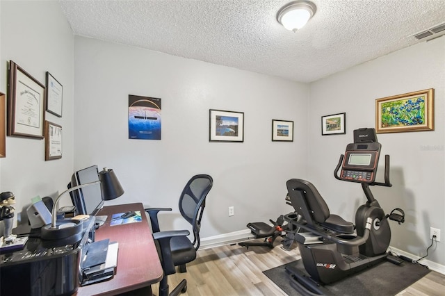 office space featuring a textured ceiling and light hardwood / wood-style flooring