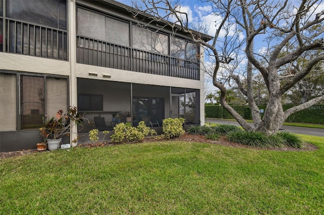 rear view of property featuring a lawn