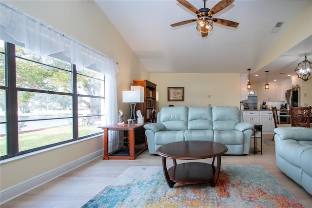 living room with light wood-style floors, visible vents, ceiling fan with notable chandelier, and a healthy amount of sunlight