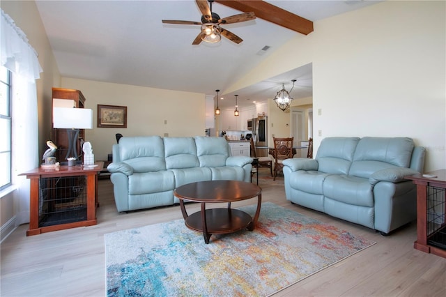living room with light wood finished floors, visible vents, ceiling fan with notable chandelier, and vaulted ceiling with beams