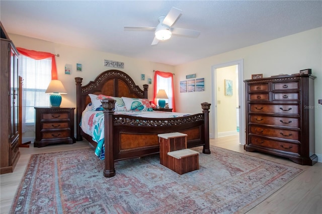 bedroom with multiple windows, ceiling fan, and light wood-type flooring