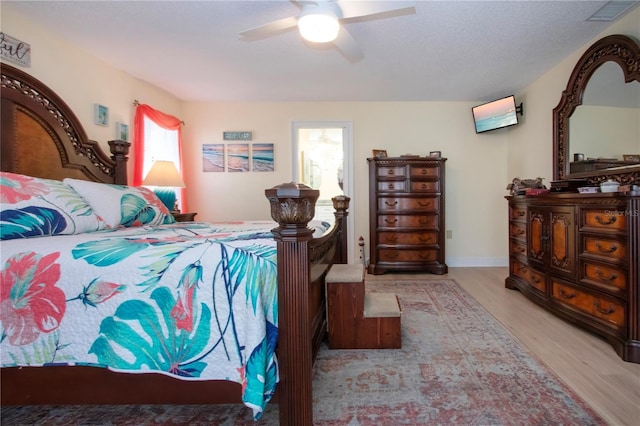 bedroom featuring a textured ceiling, visible vents, light wood-style flooring, and ceiling fan
