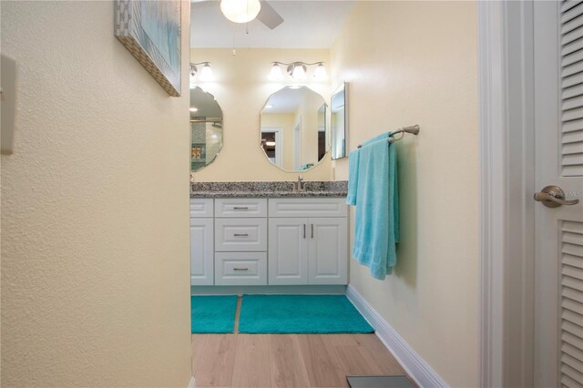 bathroom featuring vanity, ceiling fan, and wood finished floors