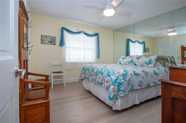 bedroom with light wood-style flooring, baseboards, and ceiling fan