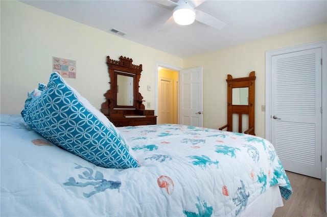 bedroom with visible vents, wood finished floors, and a ceiling fan