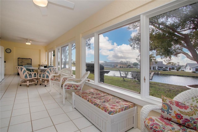 sunroom / solarium with a water view and tile patterned flooring