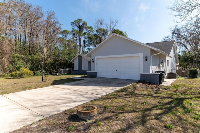 view of side of property featuring a yard, a garage, and central AC unit