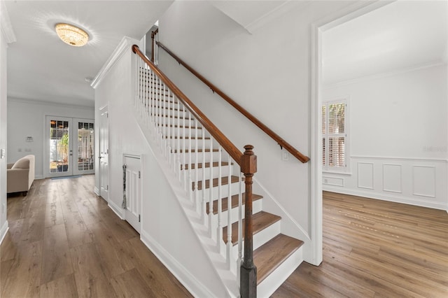 stairs featuring hardwood / wood-style flooring, ornamental molding, and french doors