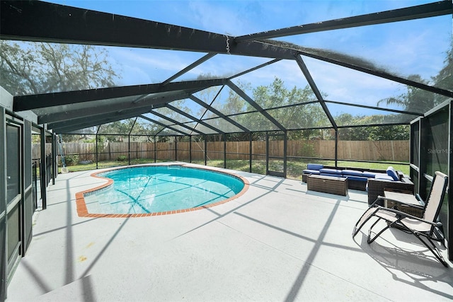 view of swimming pool with an outdoor living space, glass enclosure, and a patio area