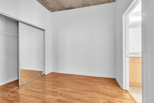777 N Ashley Dr Unit 1915, Tampa, FL 33602 - unfurnished bedroom with ensuite bathroom, light hardwood / wood-style floors, and a closet