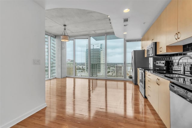 777 N Ashley Dr Unit 1915, Tampa, FL 33602 - kitchen featuring floor to ceiling windows, sink, hanging light fixtures, light wood-type flooring, and stainless steel appliances