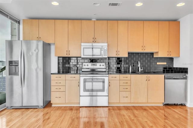 777 N Ashley Dr Unit 1915, Tampa, FL 33602 - kitchen featuring decorative backsplash, light brown cabinets, light hardwood / wood-style floors, and appliances with stainless steel finishes