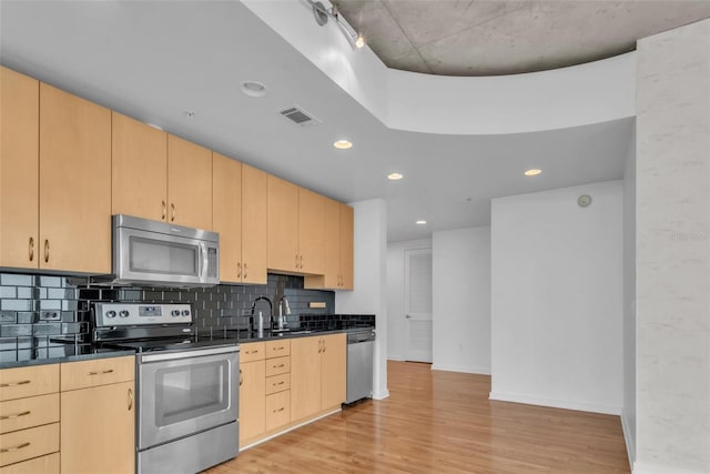 777 N Ashley Dr Unit 1915, Tampa, FL 33602 - kitchen with sink, backsplash, light hardwood / wood-style floors, stainless steel appliances, and light brown cabinets