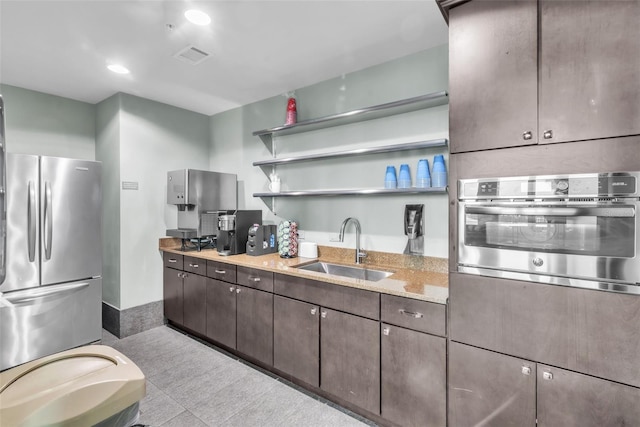 777 N Ashley Dr Unit 1915, Tampa, FL 33602 - kitchen featuring light stone countertops, appliances with stainless steel finishes, sink, and dark brown cabinets