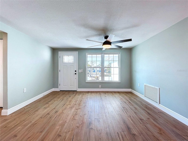 foyer featuring ceiling fan, a textured ceiling, and light wood-type flooring