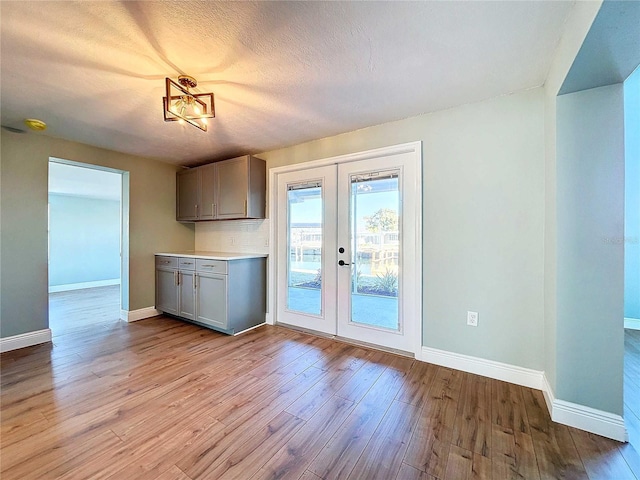 kitchen with light hardwood / wood-style flooring, french doors, a textured ceiling, and gray cabinets